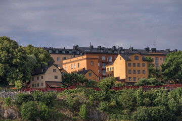 Fototapeta na wymiar Old 1800s houses at board walk at the street Monteliusvägen at the blocks at the street Bastugatan, a sunny summer day in Stockholm