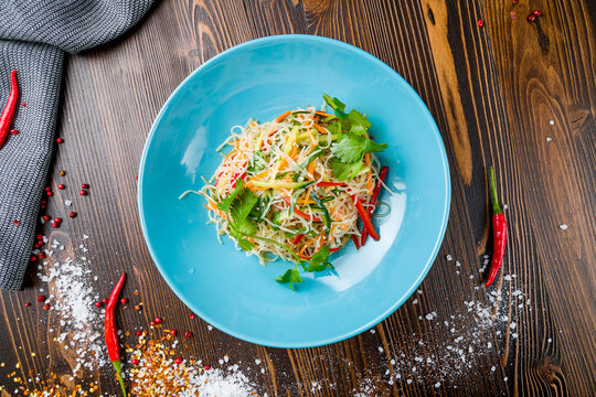 Funchosa with vegetables chinese cuisine on wooden table