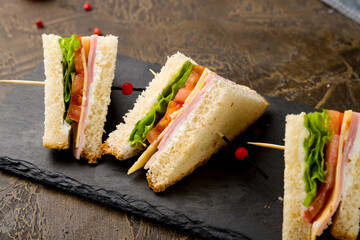 ham and cheese sandwich sliced on black stone plate