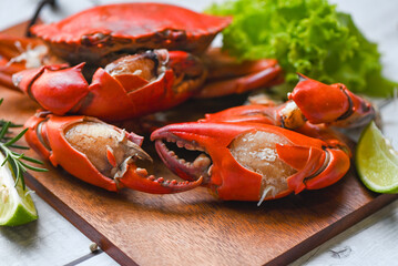 fresh crab on wooden board, claw crab cooking food seafood plate with herbs spices lemon lime salad, boiled or steamed crab red in the restaurant