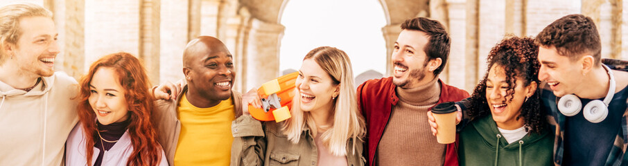 Multiracial young people walking happily on the street - Guys and girls having fun together -...
