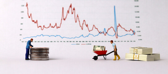 A business concept with graphs and miniature people. Miniature people moving money.
