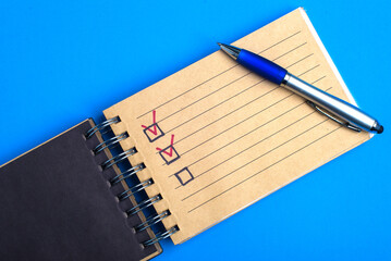 Yellow notebook with pen on blue background with a place for an inscription