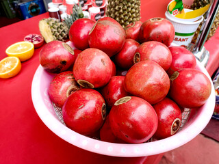 Red pomegranate fruits in basket on the table