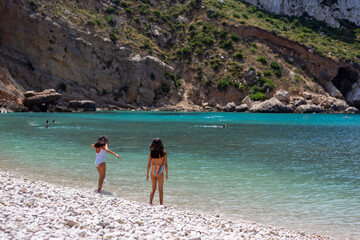 Two faceless girls on tropical beach. Children alone on the beach