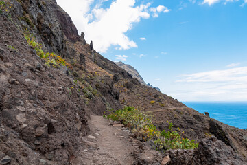 Fototapeta na wymiar Scenic coastal hiking trail from Afur to Taganana. Panoramic view of Atlantic Ocean coastline and Anaga mountain range on Tenerife, Canary Islands, Spain, Europe, EU. Beautiful pathway along the coast