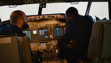 Diverse team of captain and copilot preparing to takeoff with airplane, inserting destination...