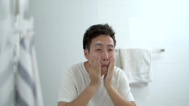 Asian young man washing his face in the morning.