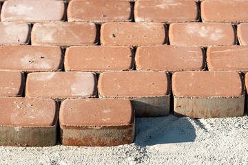 Brown concrete permeable flooring assembled on a substrate of sand. Abstract photo of bricks in the sunlight