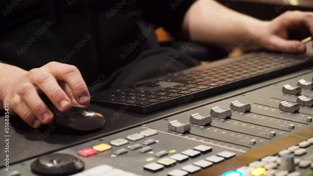 Poster man working in the studio using music console, desktop mouse and keyboard. - close up