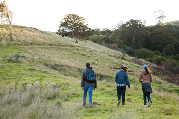 Three teens walking up a hill on a windy morning