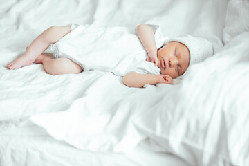 Newborn baby sleeping peacefully and sweetly on the bed, portrait