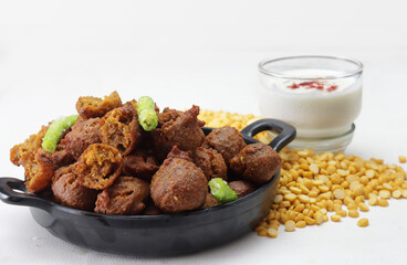 Delicious  crispy and crunchy Indian deepfried snacks Dal vada or dal pakoda or moong dal vade or pakora or fritters with green chilly and chutney or curd.