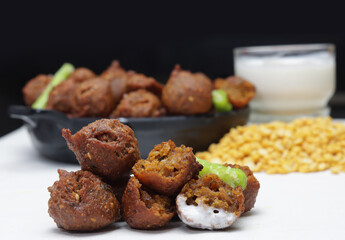 Delicious  crispy and crunchy Indian deepfried snacks Dal vada or dal pakoda or moong dal vade or pakora or fritters with green chilly and chutney or curd.