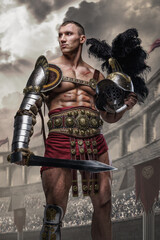 Obraz premium Art of handsome arena fighter from ancient rome with muscular build holding plumed helmet.
