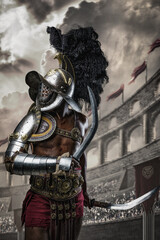 Shot of african gladiator dressed in armor and helmet posing with two swords in arena.