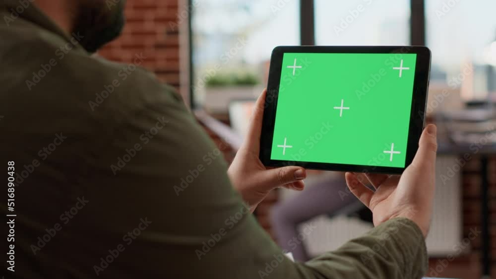 Poster office worker holding horizontal greenscreen on tablet, analyzing chroma key display with isolated m