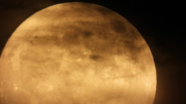 timelapse of a full moon being gradually covered by dark clouds on the sky