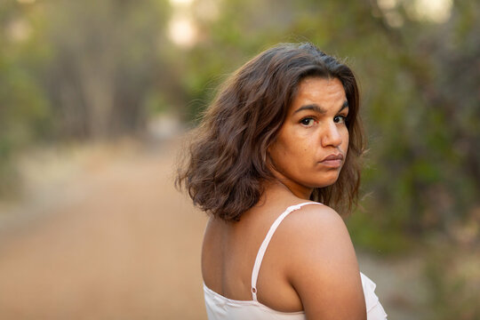 aboriginal woman outdoors looking back over her shoulder