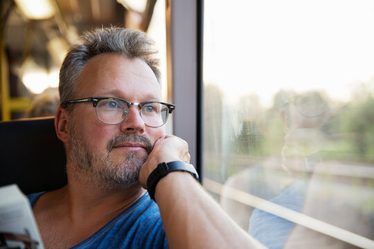 Mid adult man at window of train