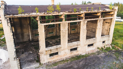 an abandoned brick building with a flat roof. Small windows without glass,