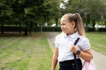 happy blonde curly schoolgirl in school uniform with pink backpack back to school outdoor