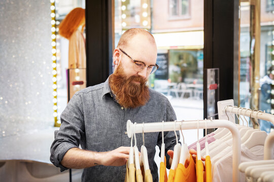 Small business owner organising clothes in store