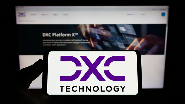 Stuttgart, Germany - 07-10-2022: Person holding smartphone with logo of US IT consulting firm DXC Technology Company on screen in front of website. Focus on phone display.
