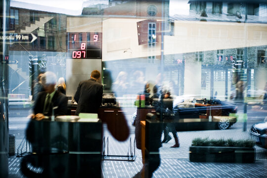 Reflection of people in window and city street