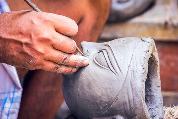 Creating clay head of goddess Durga in Kumartuli, Kolkata, India. The idols are made for the Hindu...