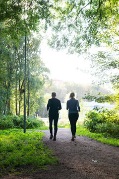 Man and woman jogging on trail in forest