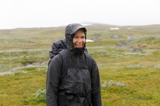 Smiling woman in hooded jacket during hike