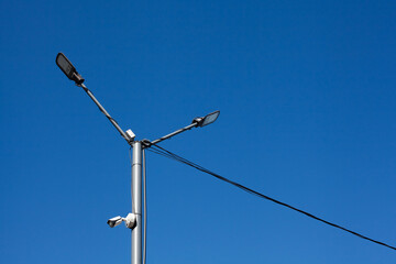 Fototapeta na wymiar A modern street LED lighting pole for sity with blue sky. Urban electro-energy technologies. Savings on street urban road lighting.