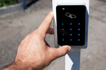 The client touches the card reader for access cards to enter the parking lot with his finger.
