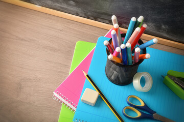 School supplies with penholder on notebooks on desk elevated view