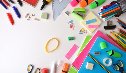 Assortment of colorful school supplies on white desk top view