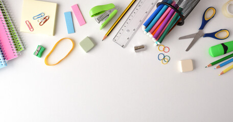 Background with school supplies on white table on top - obrazy, fototapety, plakaty