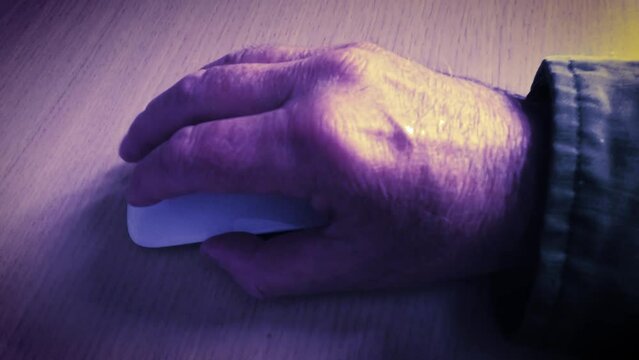 Slow motion hand using a mouse at night. Sinister, creepy or secretive concept.