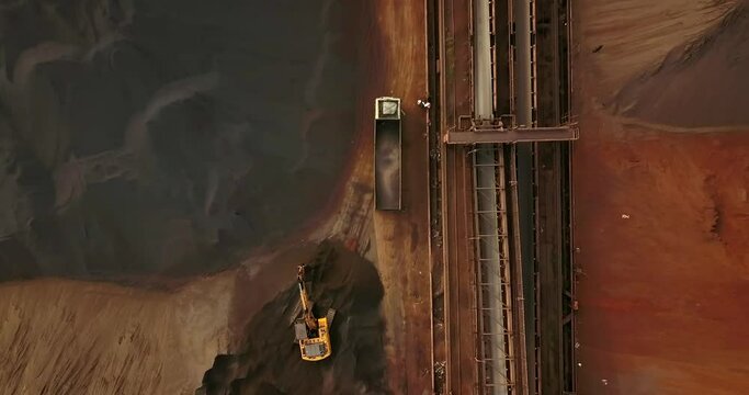 Excavator Loading Dump Trucks With Coal At Industrial Port In Paradip, India. - aerial descend, overhead
