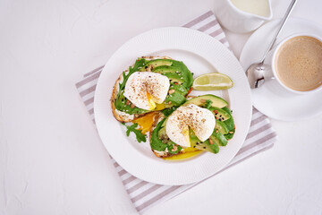 Freshly made poached egg and Avocado toasts on light grey background