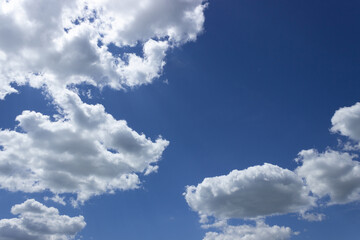 White clouds in a blue sky on a sunny summer day. Background, blank