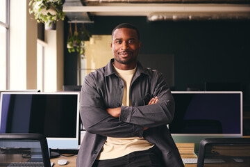 Smiling Young Black Male Standing In Office Looking At Camera With Arms Crossed - Powered by Adobe