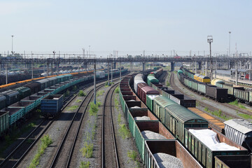 Fototapeta na wymiar Freight wagons with cargo at the railway station. Major transport railway junction. Sending wagons for export.
