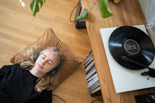 Teenage girl listening to music on record player