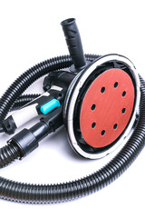 Electric rotary grinder and black corrugated hose for a vacuum cleaner on a white background