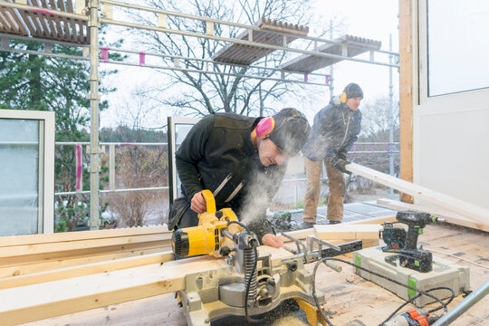 Carpenters cutting wood in house