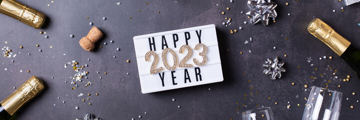 Happy New Year greeting card, 2023 with champagne, confetti, banner