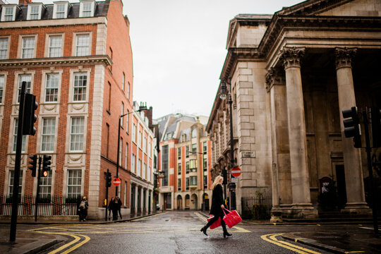 Young woman walking with shopping bags on street