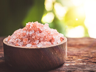 Fototapeta na wymiar Pink himalayan salt in wooden bowl on wooden table