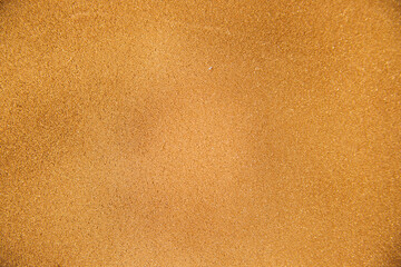 Abstract background made of foam sponge, painted in gold color. Uneven surface. Festive texture.